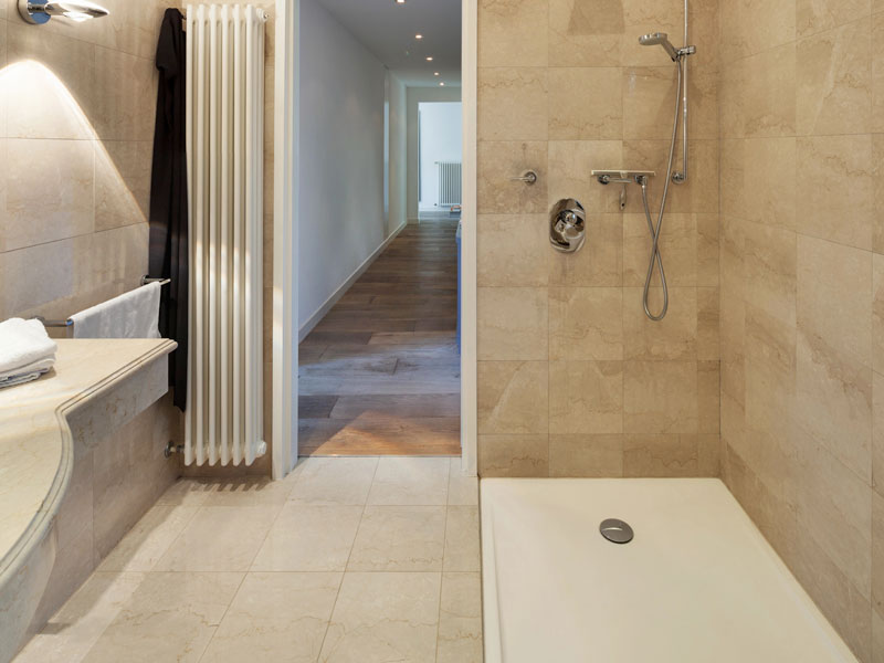 Wand- und Bodenfliesen aus dem Naturstein Botticino mit passendem Waschtisch