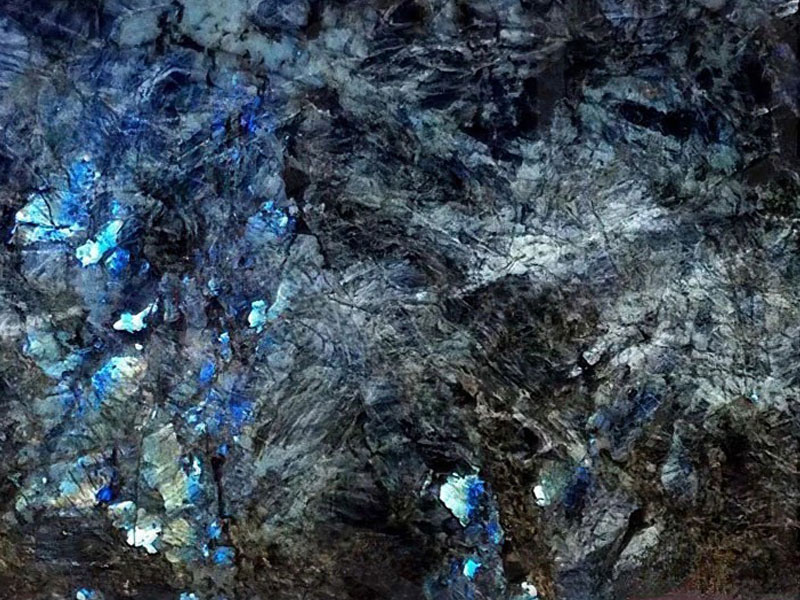 Nahaufnahme einer hochglanzpolierten Natursteinoberfläche. Diese Steinoberfläche verleiht dem Stein eine optische Tiefenwirkung.