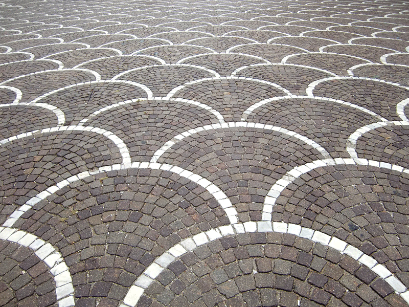 porphyr pflastersteine im rundbogen mit weissen marmor pflastersteinen umrandet